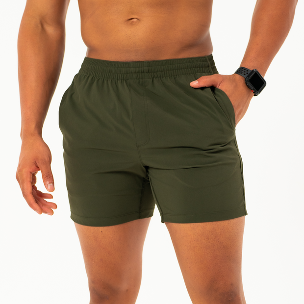 Atlas Short 5.5 Inch Military Green Front on model with hand in inseam pocket