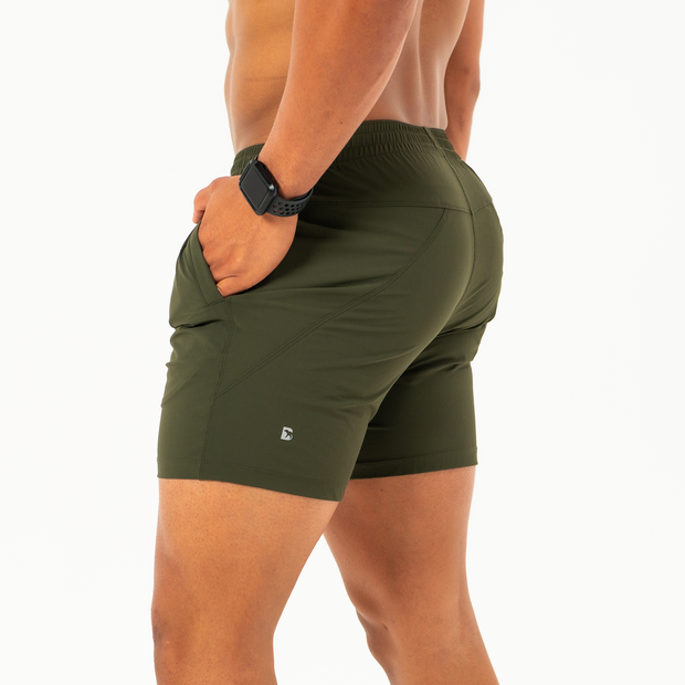Atlas Short 5.5" Military Green left side on model with hand in inseam pocket