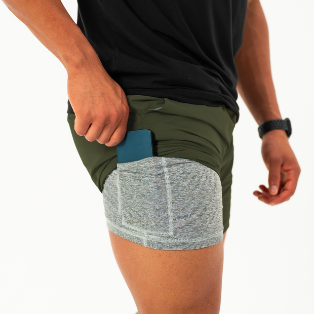 Base Short 7" Military Green on model showing  grey heather liner that has a built-in phone pocket