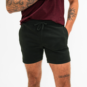 Alto Short 5.5" inseam in Black front on model with elastic waistband, fabric drawstring, faux fly, and two front side seam pockets