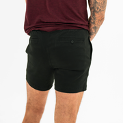 Alto Short 5.5" inseam in Black back on model with elastic waistband and two welt pocket with horn buttons