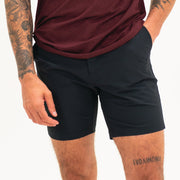 Tour Short 7" Black on model with flat elastic waistband, belt loops, snap-button, zipper fly, and two front seam pockets