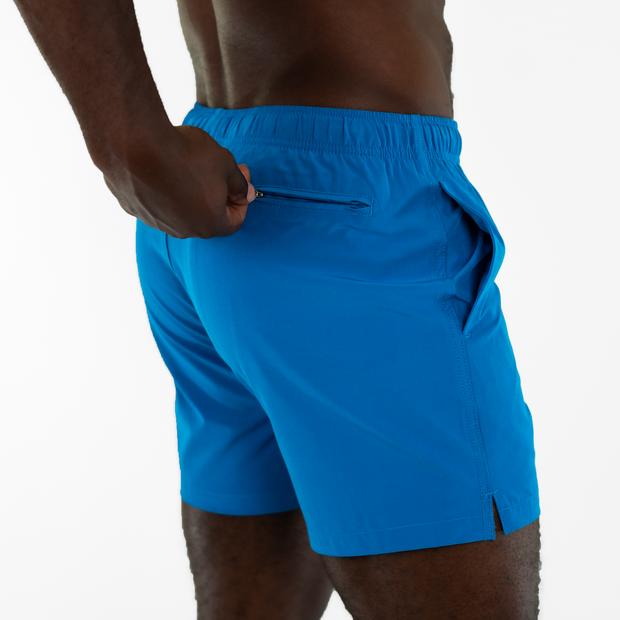 Stretch Swim 5.5" in bright azure Blue on model zipping back right zipper