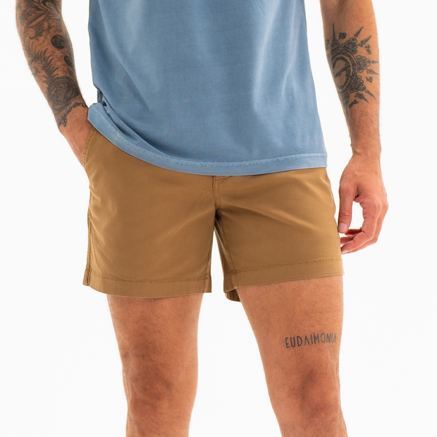 Stretch Short 5.5" Camel front on model with zipper fly and two inseam pockets worn with Natural Dye Logo Tee Ocean