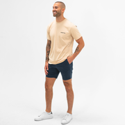 Stretch Chino Short 7" in Navy on model angled 45 degrees worn with Natural Dye Logo Tee in Sand