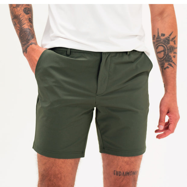 Tour Short 7" Dark Olive on model with flat elastic waistband, belt loops, snap-button, zipper fly, and two front seam pockets