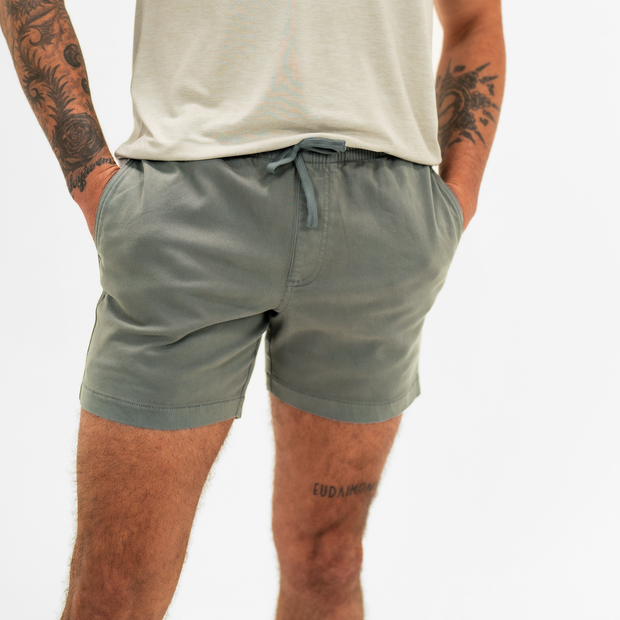 Alto Short 5.5" inseam in Grey front on model with elastic waistband, fabric drawstring, faux fly, and two front side seam pockets