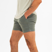 Alto Short 5.5" inseam in Grey side on model with elastic waistband, fabric drawstring, faux fly, and two front side seam pockets