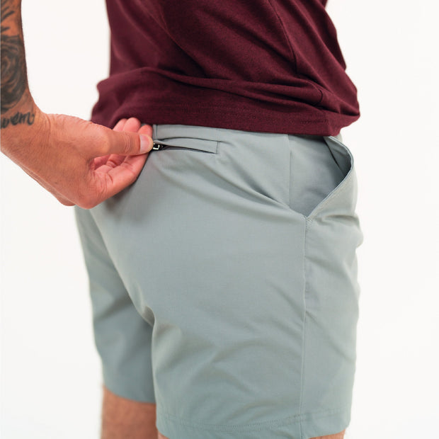 Tour Short 5.5" Grey on model with back zipper pockets and logo above back right pocket