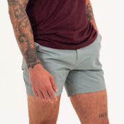 Tour Short 5.5" Grey on model with flat elastic waistband, belt loops, snap-button, zipper fly, and two front seam pockets