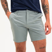 Tour Short 7" Grey on model with flat elastic waistband, belt loops, snap-button, zipper fly, and two front seam pockets