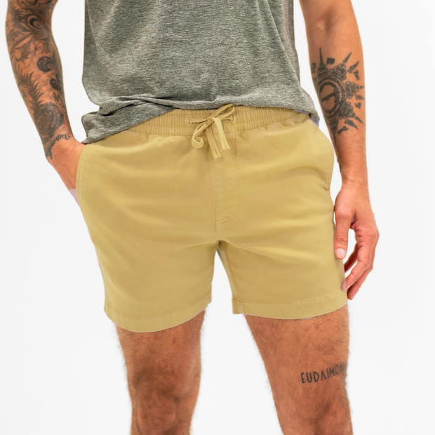 Alto Short 5.5" inseam in Khaki front on model with elastic waistband, fabric drawstring, faux fly, and two front side seam pockets