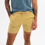 Alto Short 7" inseam in Khaki front on model with elastic waistband, fabric drawstring, faux fly, and two front side seam pockets