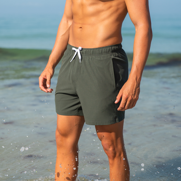 Stretch Swim Solid 5.5" Military Green close up on model standing in water on the beach