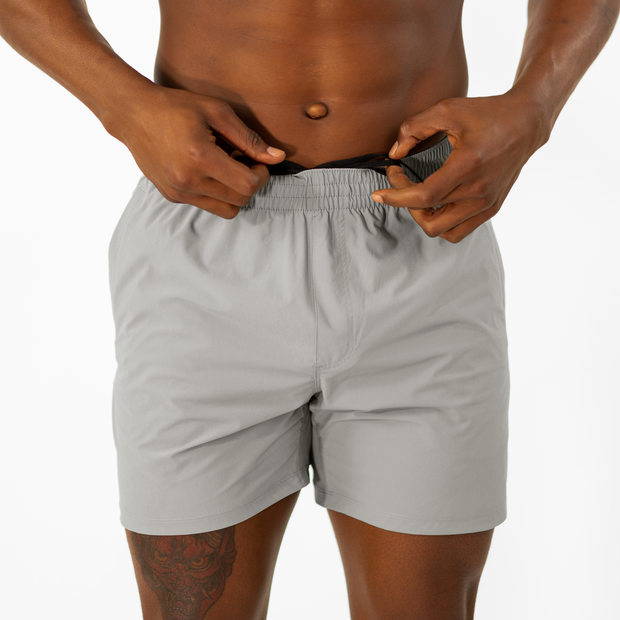 Atlas Short 5.5" Grey front on model tying drawstring hidden inside waistband
