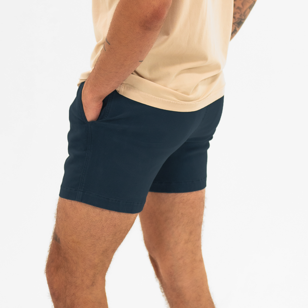 Alto Short 5.5" inseam in Navy side on model with elastic waistband, fabric drawstring, faux fly, and two front side seam pockets