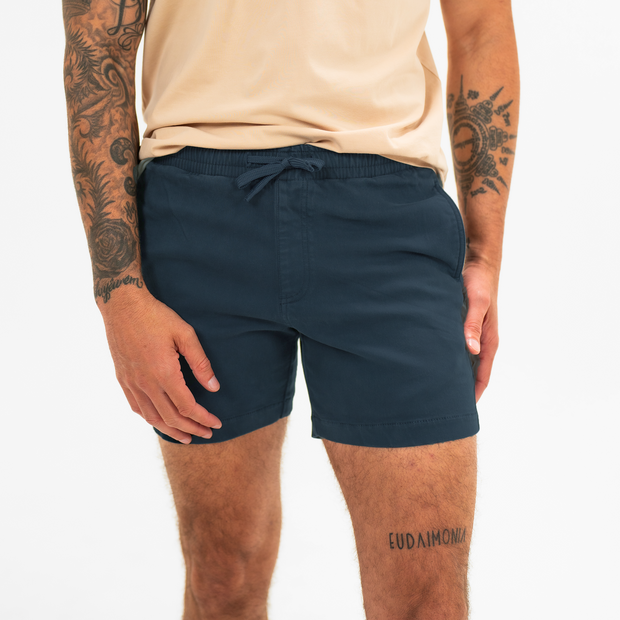 Alto Short 5.5" inseam in Navy front on model with elastic waistband, fabric drawstring, faux fly, and two front side seam pockets