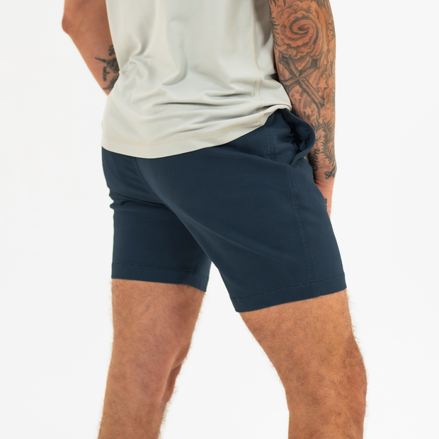 Alto Short 7" inseam in Navy back on model with elastic waistband and two welt pocket with horn buttons