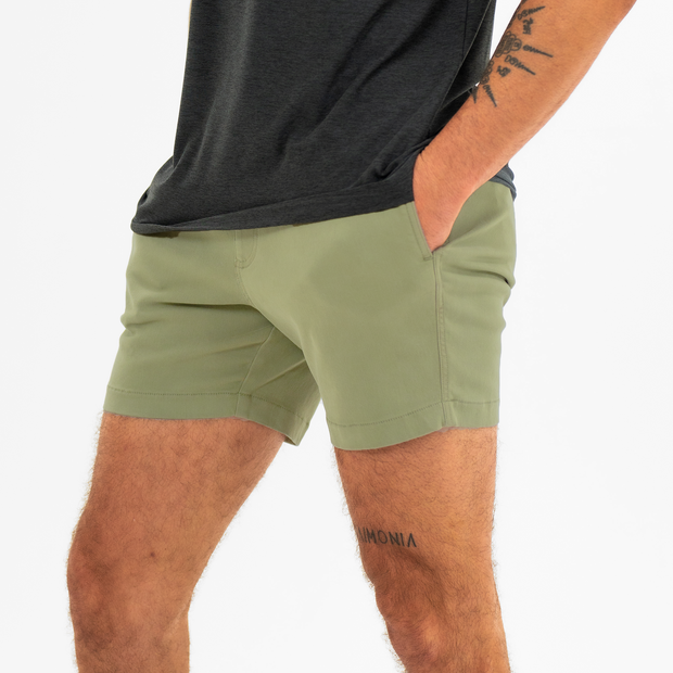 Alto Short 5.5" inseam in Olive side on model with elastic waistband, fabric drawstring, faux fly, and two front side seam pockets