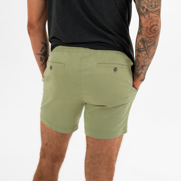 Alto Short 5.5" inseam in Olive back on model with elastic waistband and two welt pocket with horn buttons