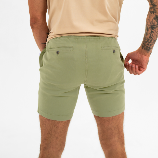Alto Short 7" inseam in Olive back on model with elastic waistband and two welt pocket with horn buttons