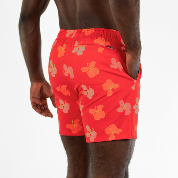 Stretch Swim 7" Hibiscus back on model with hand in inseam pocket with back right zippered pocket shown